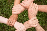 Sześć dłoni trzymające się za nadgarstki, z których powstał sześciokąt.