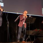 mężczyzna gra na harmonijce na scenie