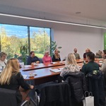 Sala konferencyjna z uczestnikami posiedzenia Rady, w tle okno z widokiem na zewnątrz