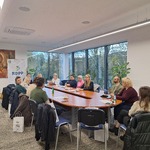 Sala konferencyjna z uczestnikami posiedzenia Rady, na ścianie obraz w ciepłych barwach, obok baner RDPP;
