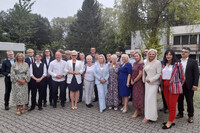 Grupa elegancko ubranych ludzi, pozują do zdjęcia.